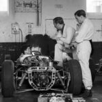 Auf ein Wort: Die Lotus-Boys Trevor Taylor (im Cockpit) und Jim Clark lauschen andächtig Colin Chapman